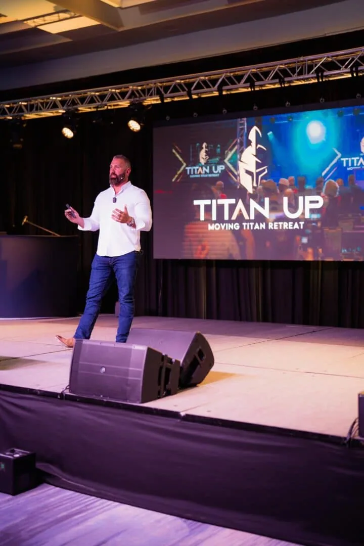 Regan Weiss speaking on stage at the Titan Up retreat