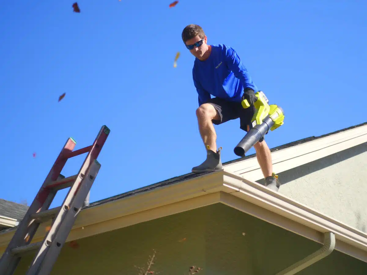 Bay Area Pressure Cleaning employee blowing leaves off a roof